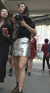 拍照的银色包臀皮裙丝袜美腿美女