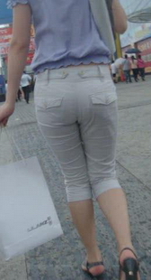 街拍雨天打伞的白裤美眉