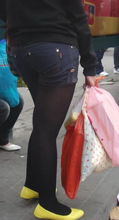 公交车站黑丝牛仔热裤美女的黄鞋很显摆