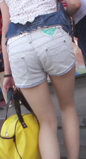 街拍热裤肉丝美眉在阳光照射下，丝袜明亮了起来