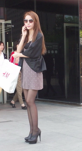 街拍修长的黑丝美腿墨镜美女，飘逸的裙子被风吹起