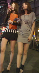 街拍夜幕下两个漂亮美眉，手里拿这么多数码产品，当心触电哦