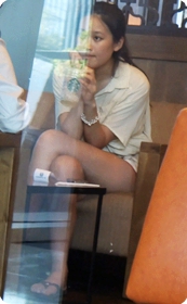坐在咖啡店里喝咖啡的短裙美眉