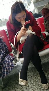 高铁站候车大厅等车的黑色丝袜美腿少妇