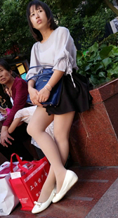 街拍黑色短裙肉色丝袜白鞋少妇