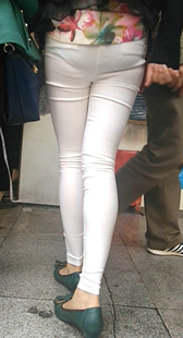 带孩子逛街的紧身白裤少妇