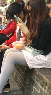 白丝短裙小妹玩手机