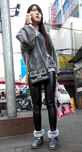 给闺蜜打电话的紧身皮裤美女好认真