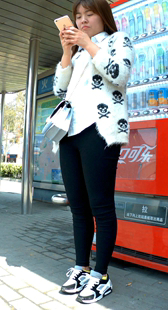 笑容真甜~玩手机的白毛衣黑色紧身裤可爱妹子