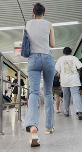 蓝色牛仔裤完美勾勒出她丰腴的臀部